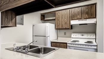 a kitchen with white appliances and a sink at The Timbers Apartments, Evansville